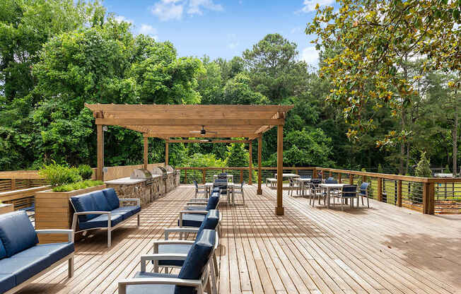 A wooden deck with blue chairs and a canopy. at Mill House at East Cobb, Marietta, GA