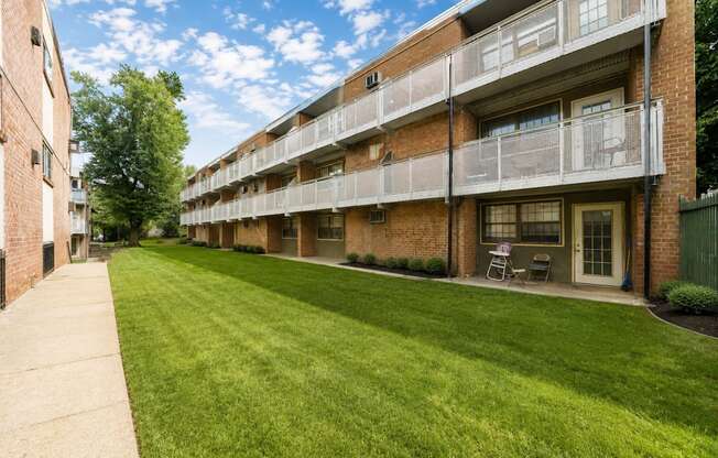 Apartment building with green lawn in front.