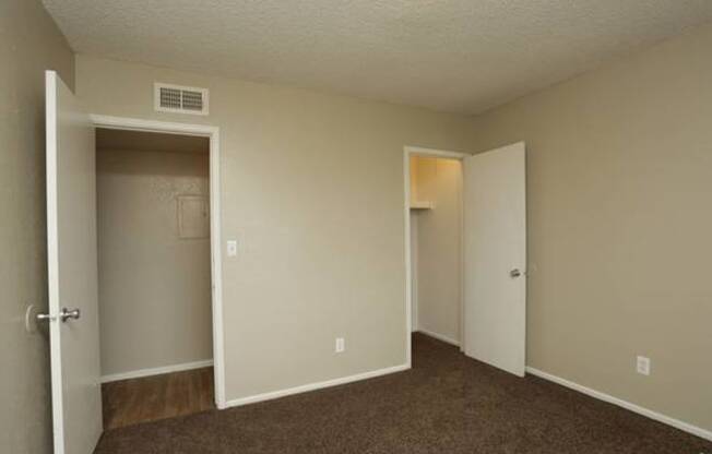 a bedroom with a door open and a closet