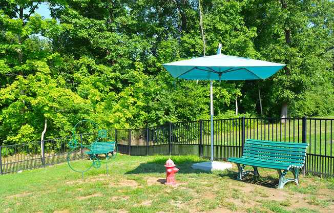 fenced pet park with umbrella and bench