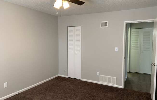 Bedroom with carpet, ceiling fan, and closet at Chouteau Heights.