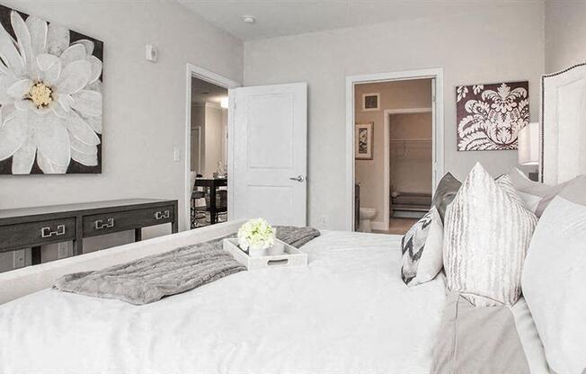 a white bedroom with a large white bed
