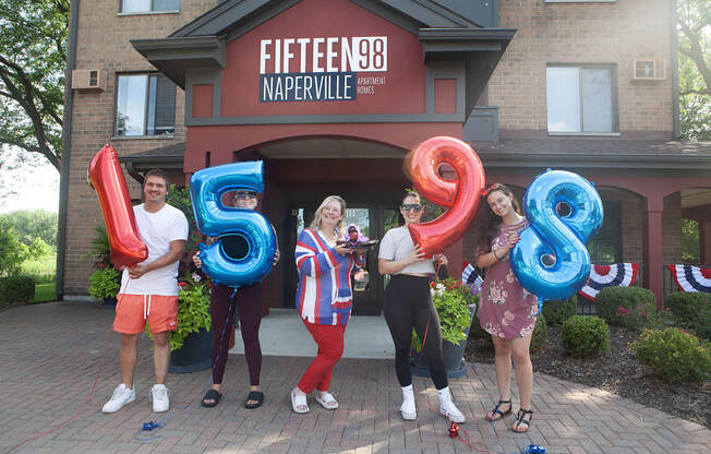 a group of people standing in front of a building holding numbers