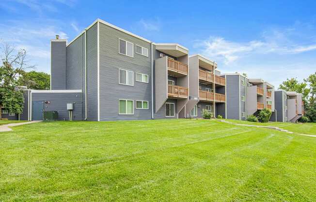 A modern apartment complex with a green lawn in front.