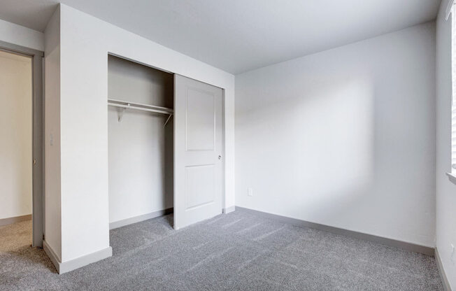 a bedroom with white walls and a closet with a white door