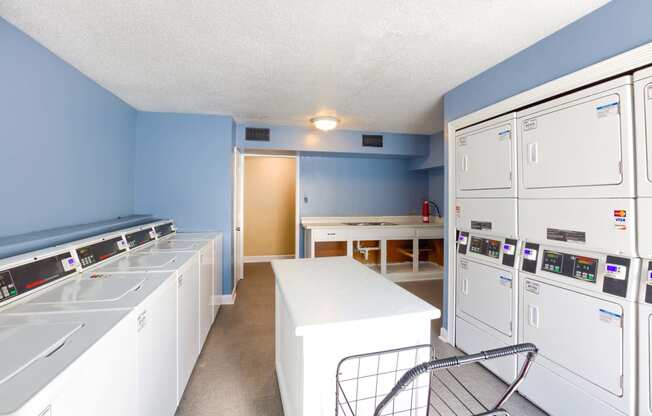 a laundry room with white appliances and blue walls