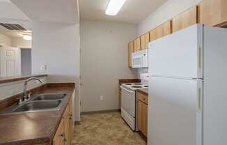 a kitchen with a sink and a refrigerator at Stetson Meadows Apartments, Colorado Springs