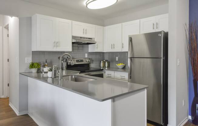 a kitchen with stainless steel appliances and white cabinets