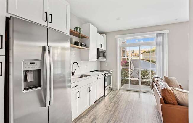 A modern kitchen with stainless steel appliances and white cabinets.