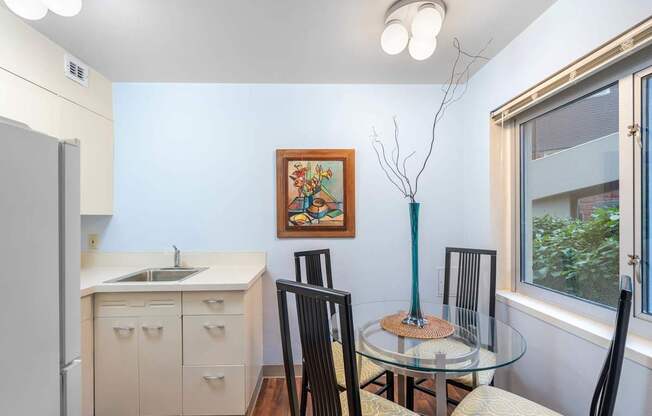 a kitchen and dining room with a glass table and chairs