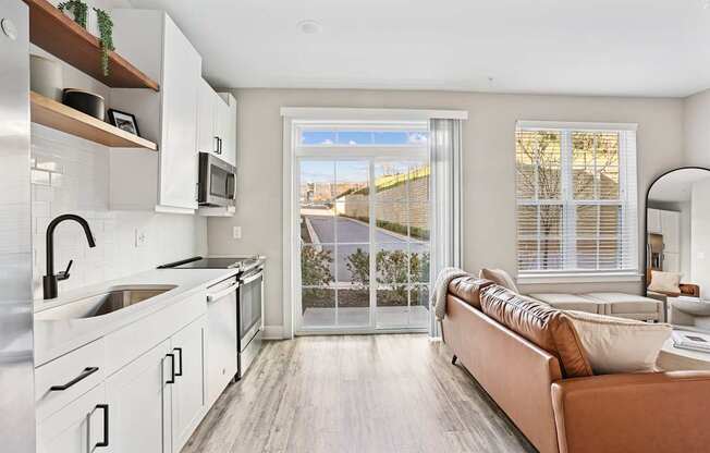 A modern kitchen with a couch and a view of the outside.