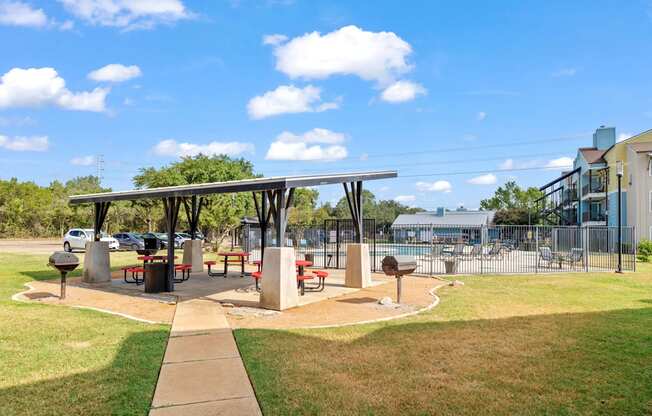 A park with a pavilion and picnic tables.