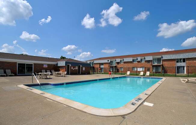 A large swimming pool in front of an apartment building at Warren Woods in Warren, MI