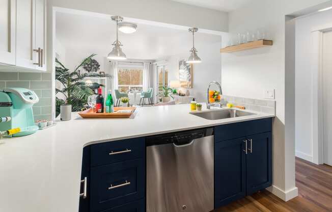 a kitchen with blue cabinets and a stainless steel dishwasher