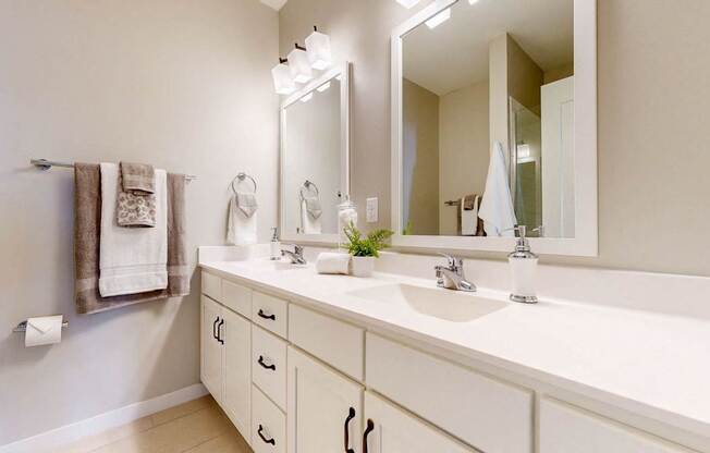 A bathroom with a white counter and a large mirror.