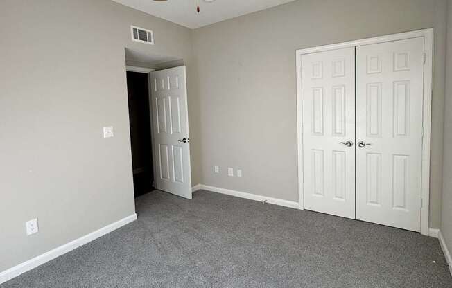 A room with a ceiling fan and carpeted floor.