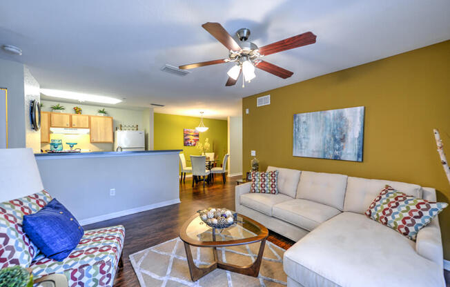 A living room with a white couch and a ceiling fan.
