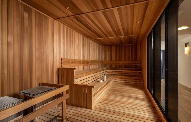 A wooden sauna with benches and a table.