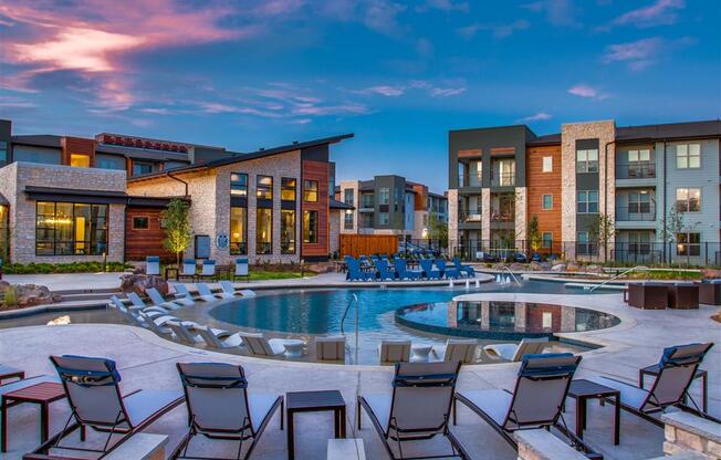 Apartments for Rent Grand Prairie - Large Sparkling Pool at Dusk Surrounded by Poolside Lounge Chairs