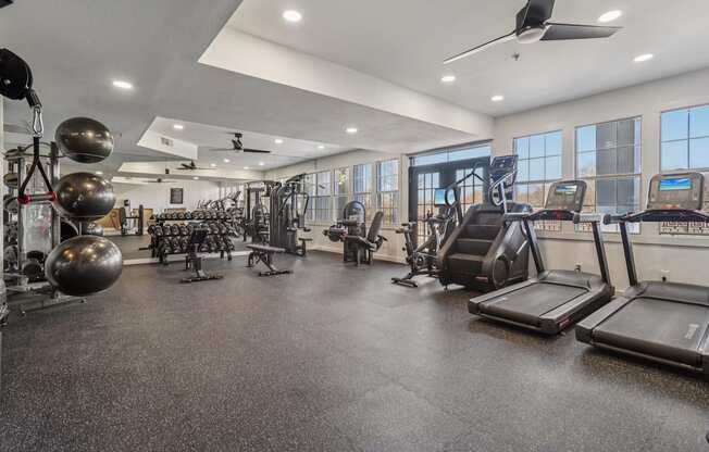 A spacious gym with treadmills, weights, and exercise equipment.
