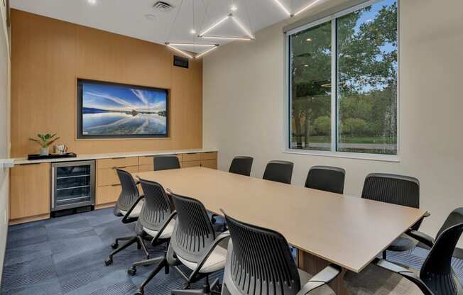 a conference room with a large window and a table and chairs