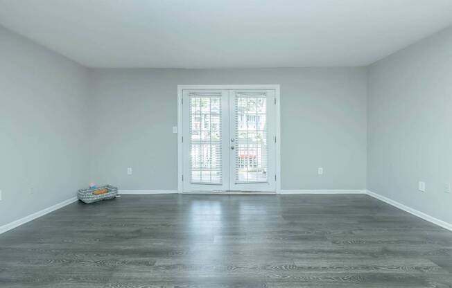 A room with a door and a trolley on the floor.