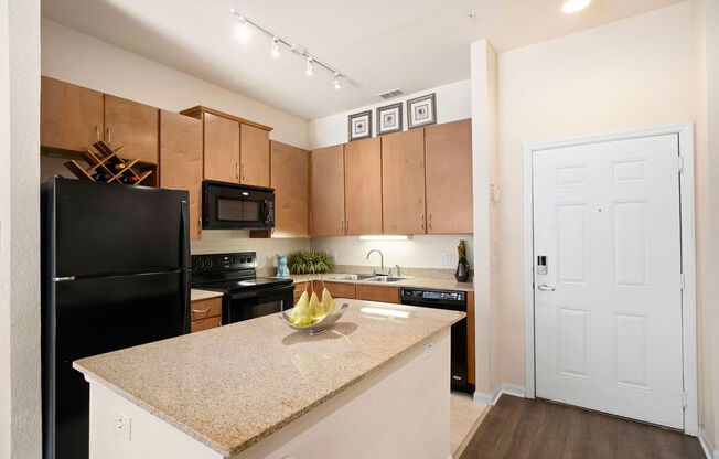 a kitchen with a granite counter top and a black refrigerator