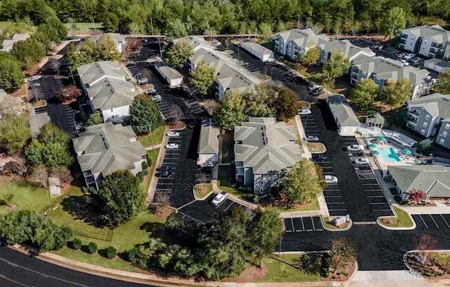 A bird's eye view of a residential area with houses and a parking lot.