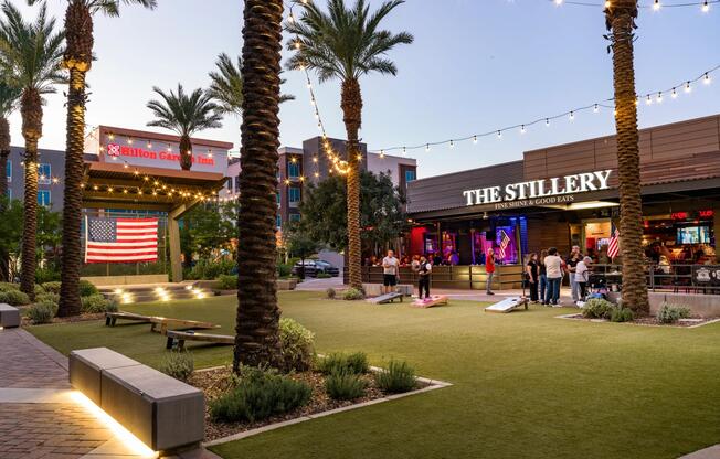 A nearby entertainment plaza in Chandler with outdoor dining, lawn games, and string lights, offering a lively evening scene close to Modera Chandler.