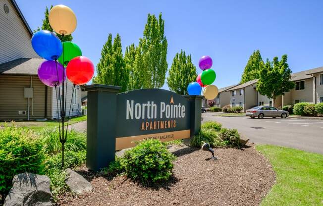a sign that says north point apartments with balloons in front of it