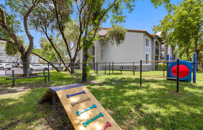 A playground with a slide and a red ball.