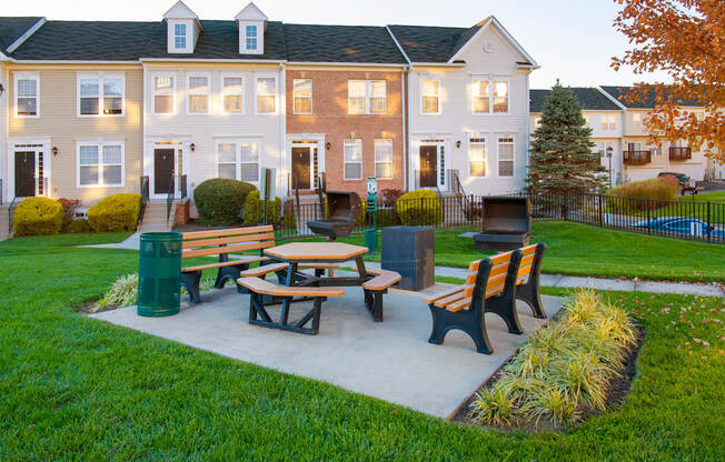 a picnic area with benches in front of an apartment building