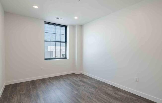 an empty living room with white walls and a window