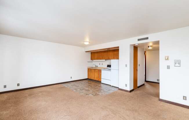 the living room and kitchen of an empty apartment with white walls and flooring