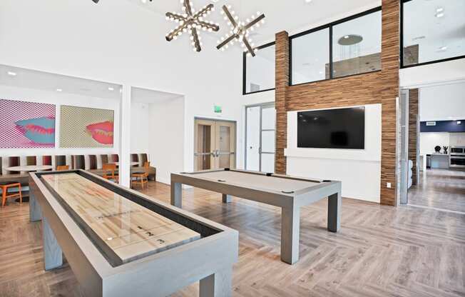 a game room with a shuffleboard table and a television