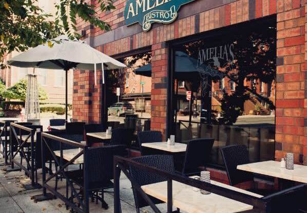 the outside of a restaurant with tables and chairs at One Ten Apartments, Jersey City