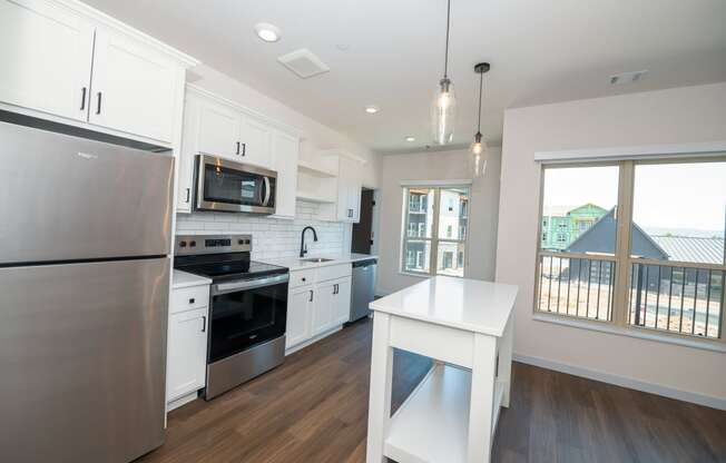 a large kitchen with white cabinets and stainless steel appliances at The Crossings at Windsong, Prescott Valley, AZ