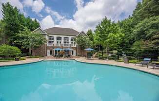 a large swimming pool with a mansion in the background