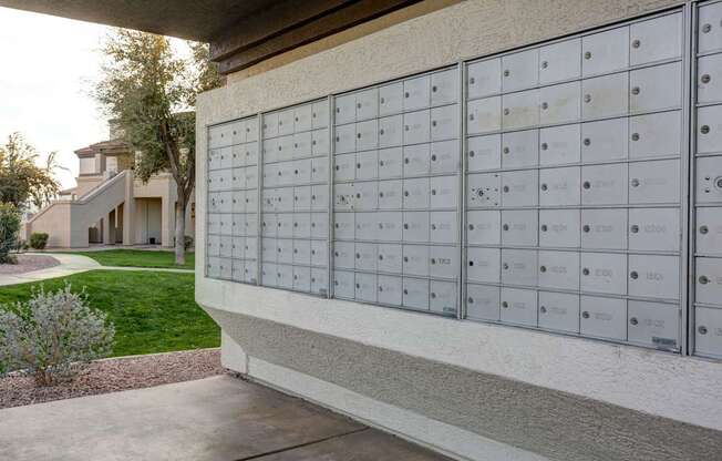 A row of mailboxes are lined up on the side of a building.