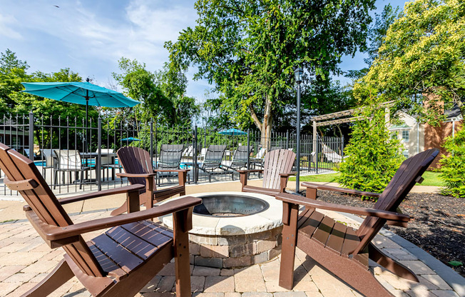 four Adirondack chairs around a fire pit