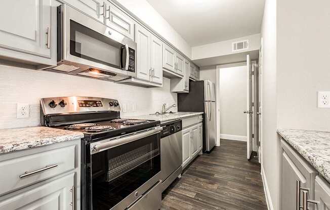 A4 apartment kitchen with upgraded cabinets and stainless steel appliances at Vine Apartments in Arlington, TX