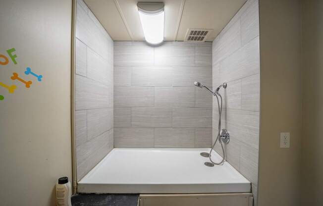 A white bathtub in a bathroom with a shower head.