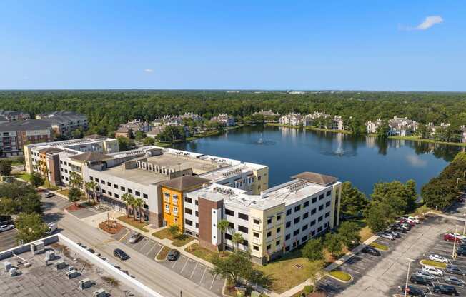 an aerial view of a building next to a lake