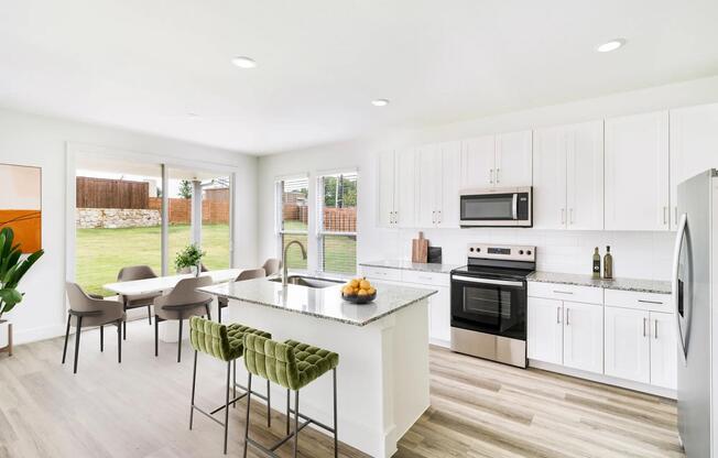 Bright and inviting, this Amavi Celina kitchen offers seamless access to a spacious backyard and covered patio perfect for relaxed Texas evenings.