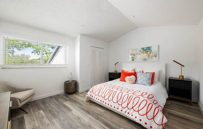 a bedroom with a bed and a couch and a window