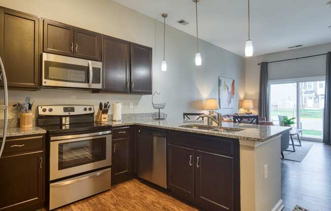 an open kitchen with stainless steel appliances and granite counter tops