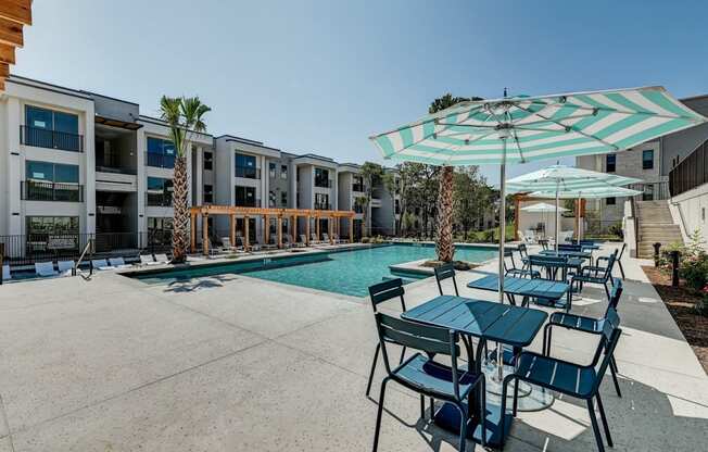 our apartments have a large pool and patio with tables and umbrellas