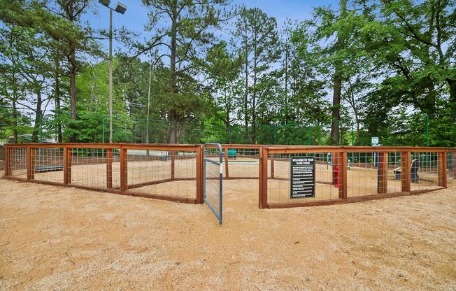 a fenced in area with trees in the background and a sign at Chapel View Apartments in Chapel Hill, NC