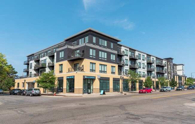 A large apartment building with a parking lot in front.