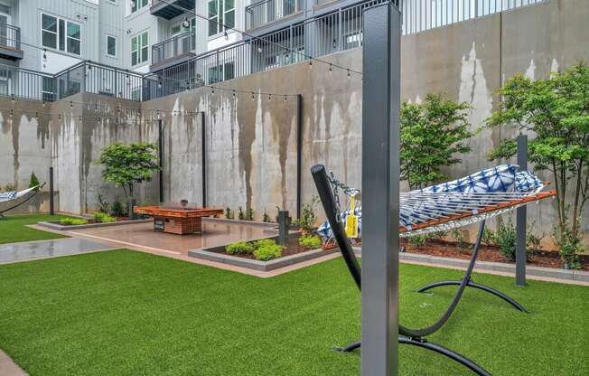 a hammock in a courtyard with a fire pit
